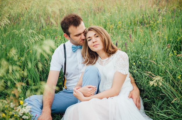 Happy Bride and groom walking on the green grass