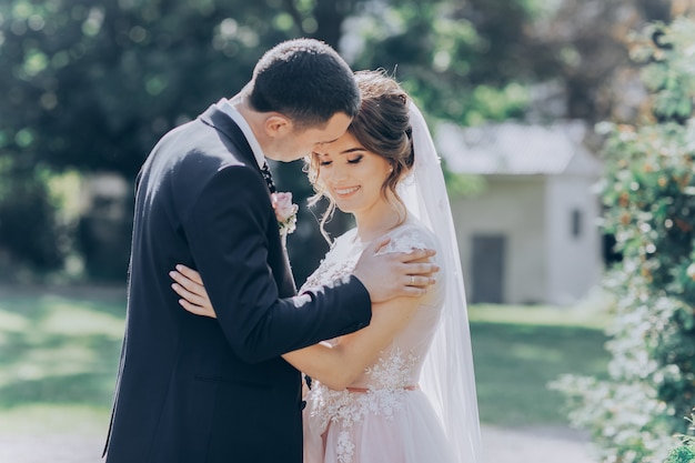 Happy bride and groom walking in the park