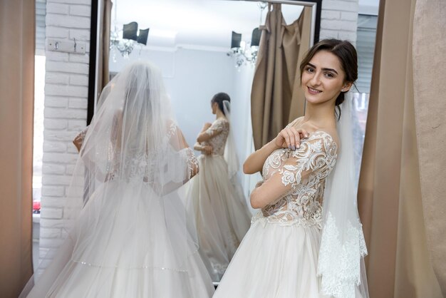 Happy bride in salon posing in wedding dress