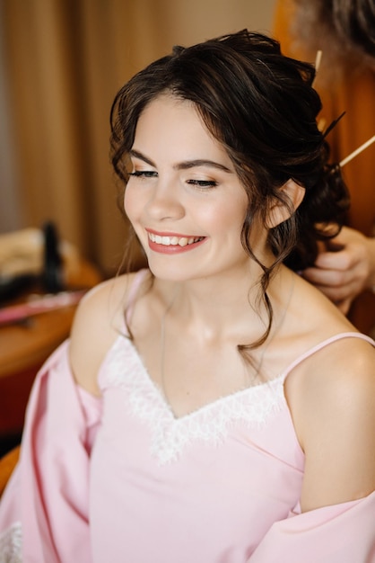 Happy bride with a smile doing her hair