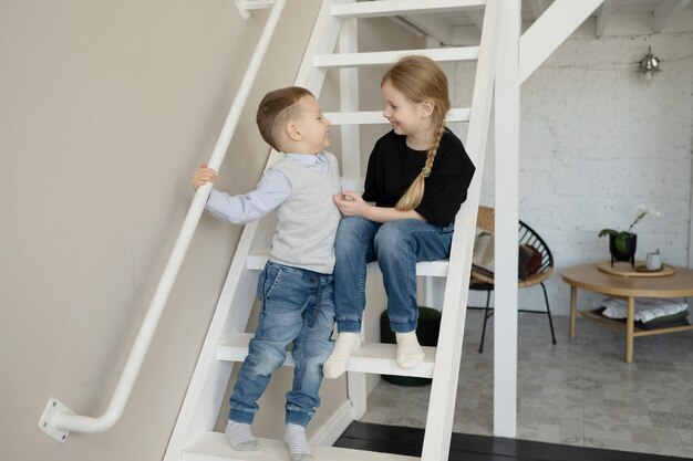 Happy brother and sister of preschool age, laughing and hugging, at home.