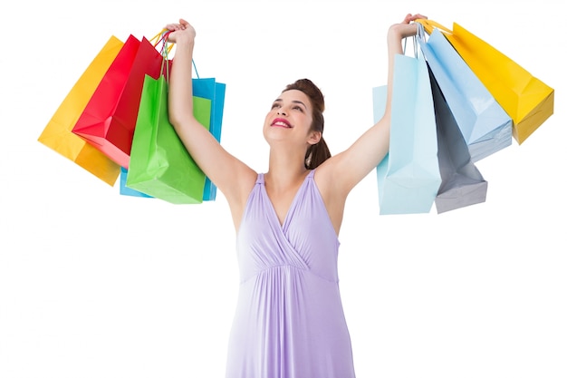 Happy brunette showing shopping bags