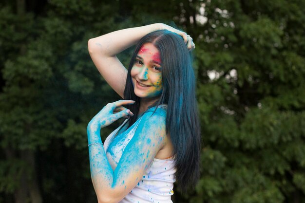 Happy brunette woman playing with powder Holi