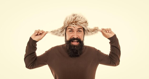 Happy brutal hipster with beard in earflape hat isolated on white background face