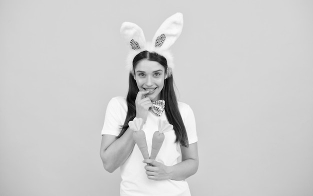 Happy bunny woman in rabbit ears with carrot easter