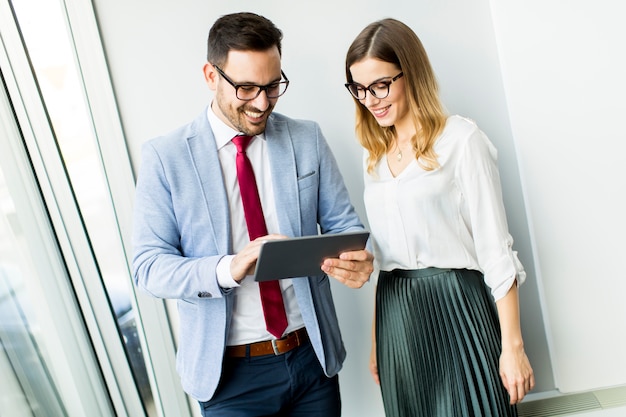 Happy business colleagues in modern office using tablet