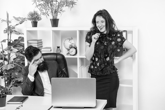 キャリアの男性と女性の幸せなビジネスカップルは、オフィスの専門家で働いています