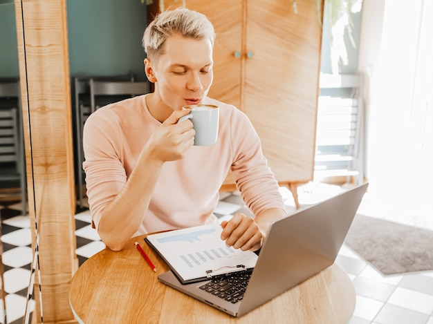 happy business man sitting at cafeteria with laptop and smartphone. businessman sitting in a cafe