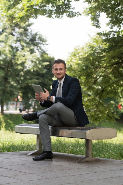 Happy Business Man Using Tablet Pc Outside On A Park Bench