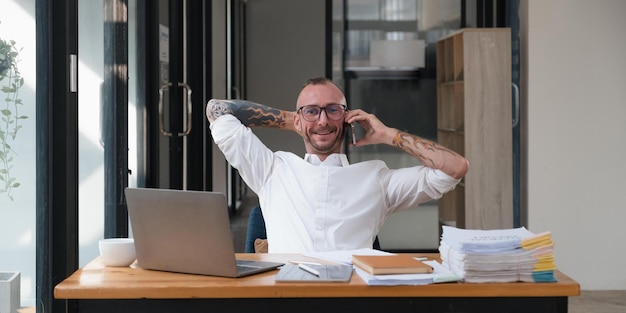 Happy business man with phone call while relaxing in the office