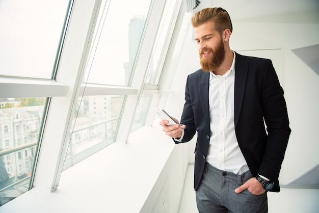 Happy business in office with his smartphone