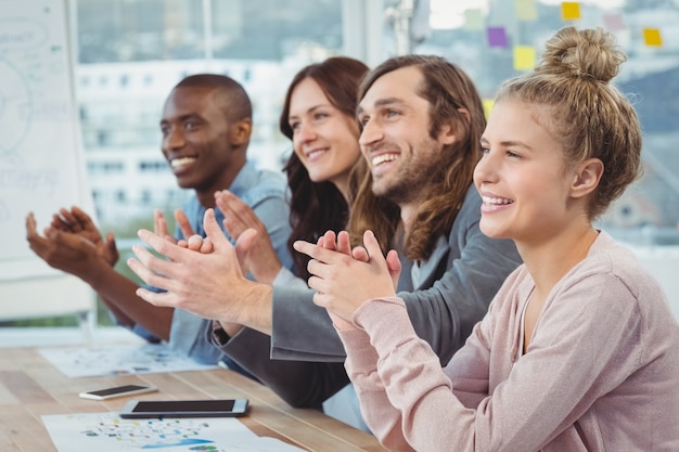 Happy business people clapping at desk 