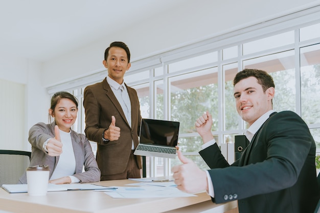 Happy business people showing thumbs up