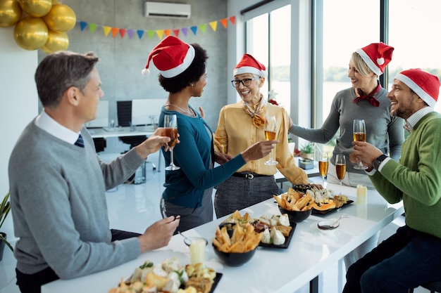 Happy business people talking while celebrating on christmas\
party in the office