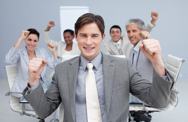 Foto squadra felice di affari che celebra un successo con le mani in su