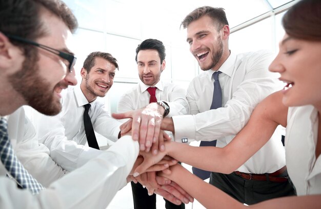 Happy business team connects their hands together the concept of teamwork