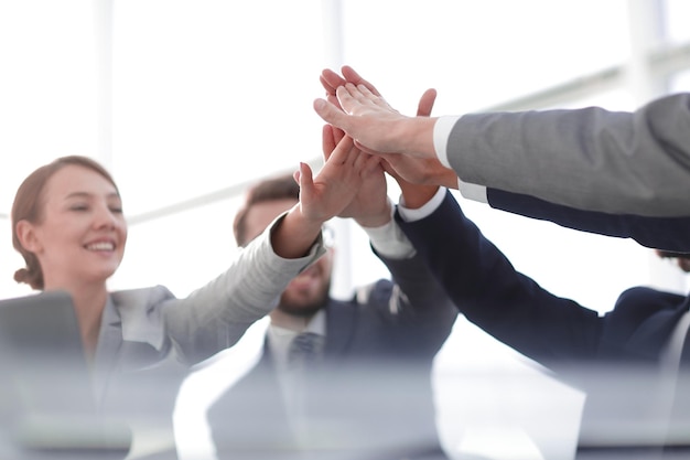 Happy business team giving high five in office