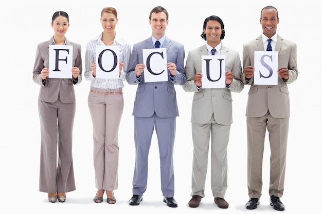 Happy business team holding the letters of FOCUS