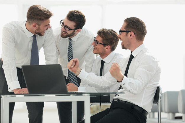 Happy business team looking at the laptop screen people and technology