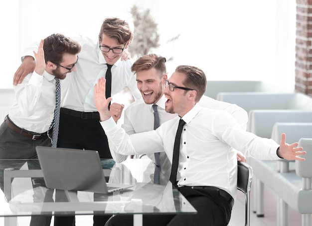 Happy business team looking at the laptop screen