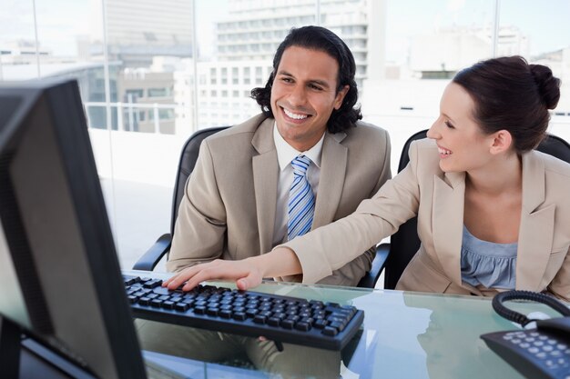 Photo happy business team using a computer