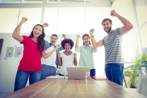 Happy business team with fists in the air 