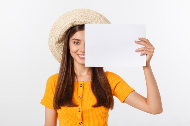 Happy business woman holding big white sign board. Gray wall back