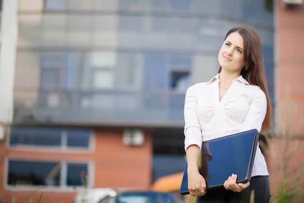 Happy business woman holding laptop and smiling