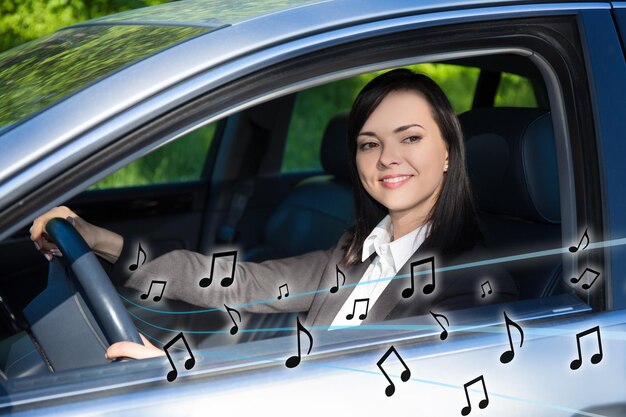 Photo happy business woman listening music in car