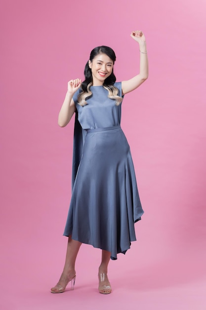 Happy business woman standing and smiling isolated on pink studio background