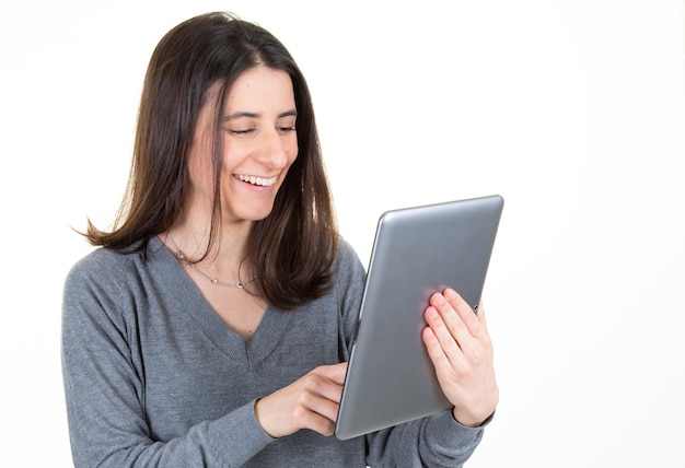 コピースペースで笑っている白い背景の上のタブレットコンピューターを使用して幸せなビジネス女性