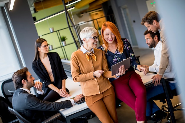 Happy business women working together online on a digital tablet at the office