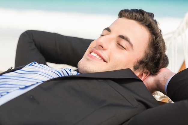 Happy businessman relaxing on the hammock