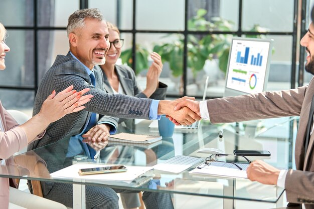 Photo happy businessman shaking hands with his financial partner