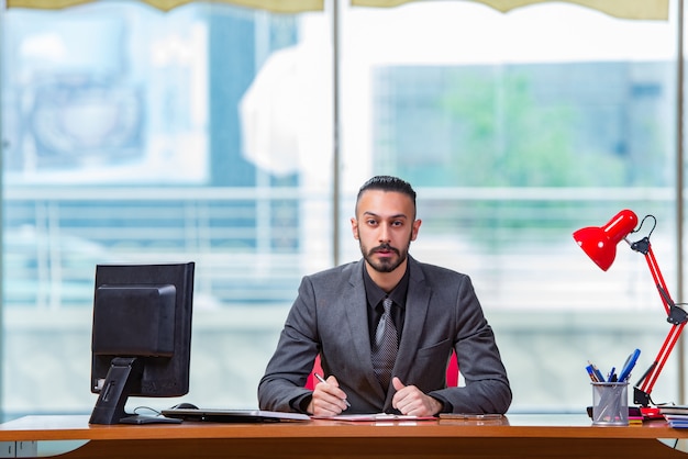 Happy businessman sitting at the desk