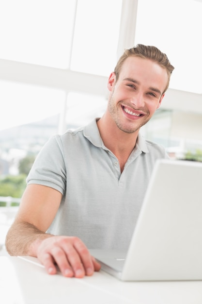 Happy businessman sitting using laptop