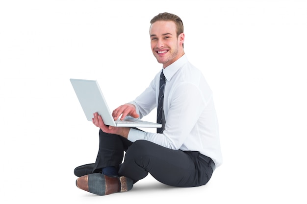 Happy businessman sitting and using laptop