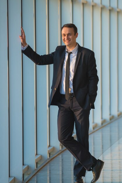 The happy businessman stand near the panoramic window