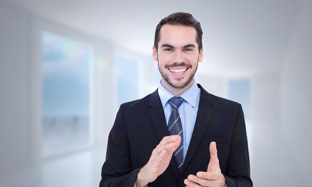 Happy businessman standing and applauding against bright white hall with columns