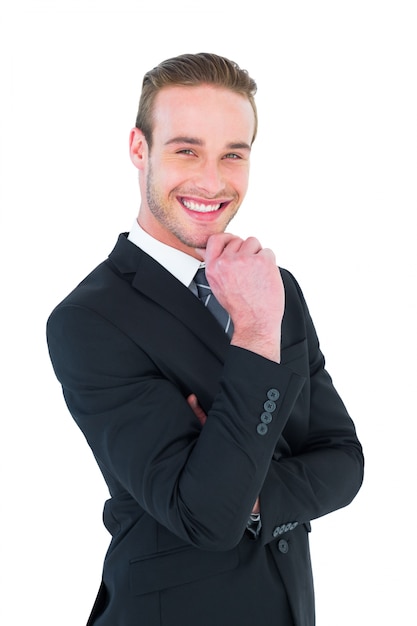 Happy businessman standing with hand on chin