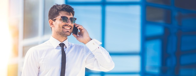 Счастливый бизнесмен в телефоне солнцезащитных очков