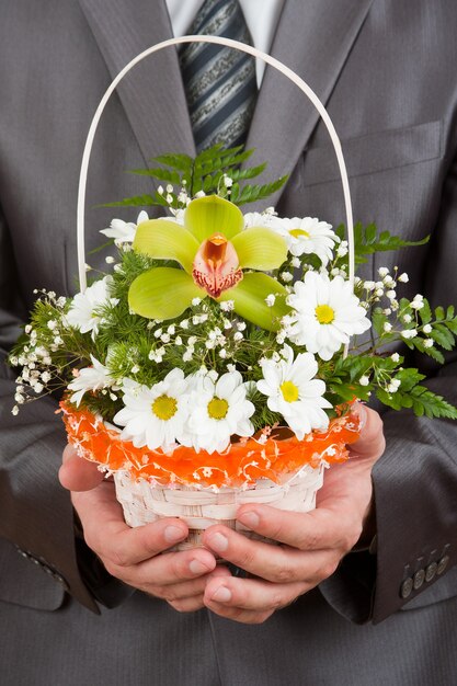 Happy businessman with basket of flowers