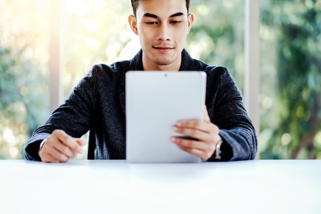 Happy Businessman Working on Digital Tablet in Office