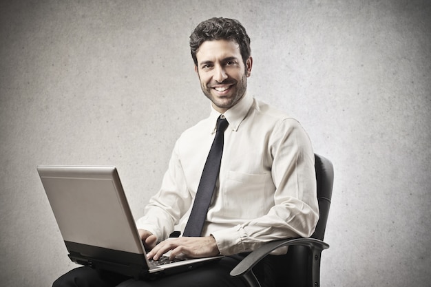 Happy businessman working on a laptop