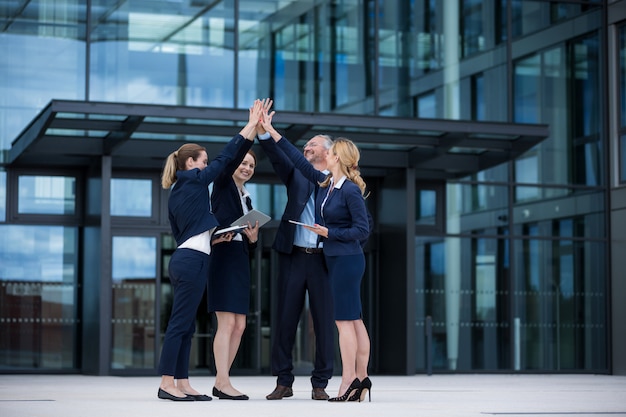 Happy businesspeople giving high five to each other