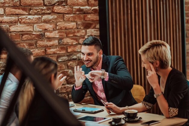 happy businesspeople smiling cheerfully during a meeting in a coffee shop group of successful business professionals working as a team in a multicultural workplace