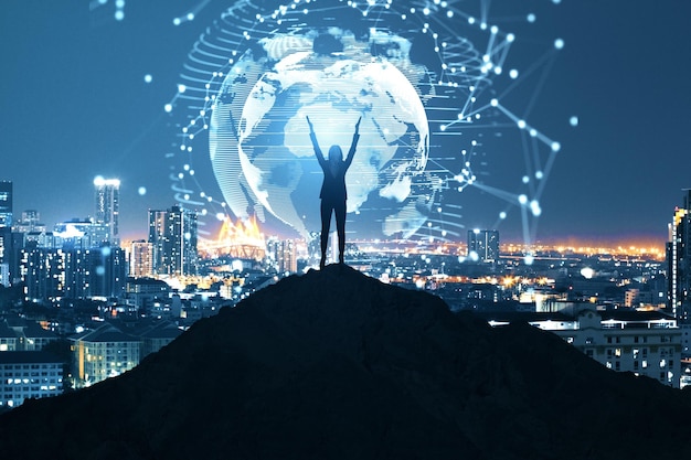 happy businesswoman on backlit hill holding abstract polygon globe hologram on illuminated night city background polygonal network security science communication programming and earth concept