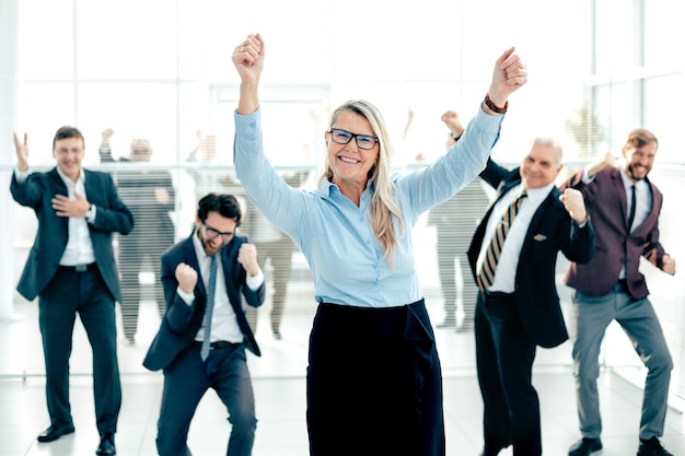 Happy businesswoman and a group of employees showing their success