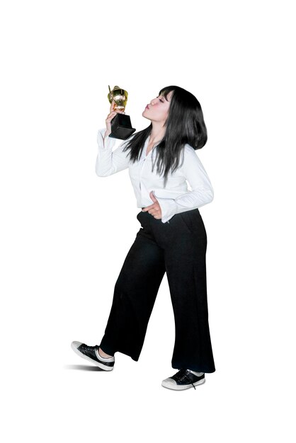 Happy businesswoman kissing a trophy on studio