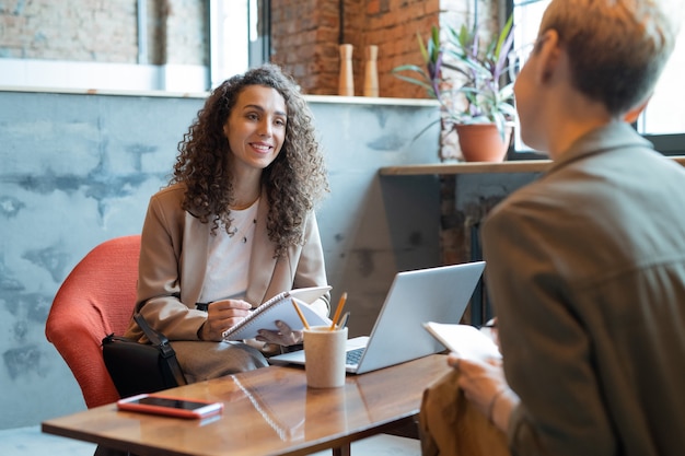 Happy businesswoman looking at colleague at business meeting